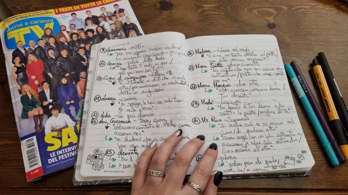 Un quaderno di appunti scritti a mano, afficati da una copia del Tv sorrisi e canzoni sul Festival di Sanremo